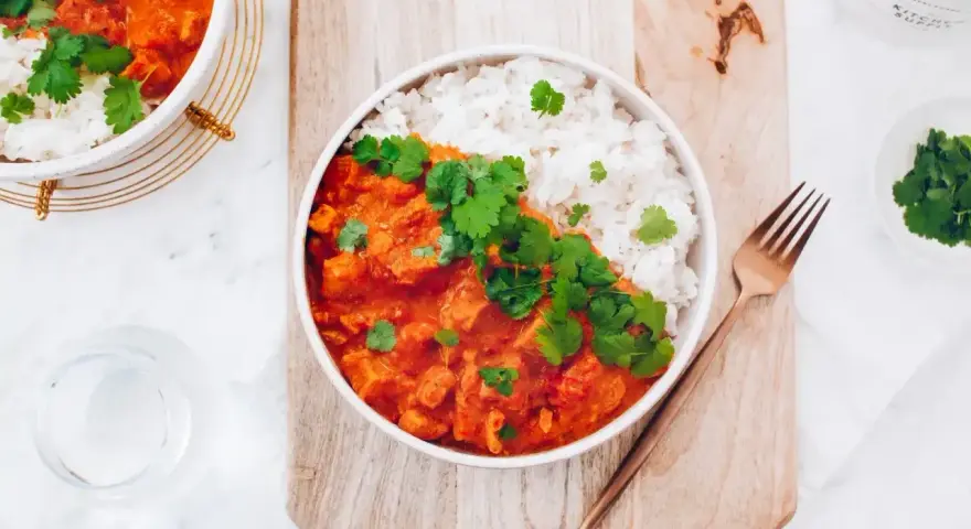 Aksamitny kurczak w czerwonym curry, podany z ryżem i świeżą kolendrą. Idealny na rozgrzewający posiłek.