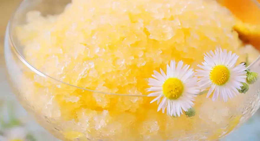 Erfrischendes Zitronen-Granita-Rezept in einem Glas, garniert mit Gänseblümchen. Perfekt für heiße Tage!