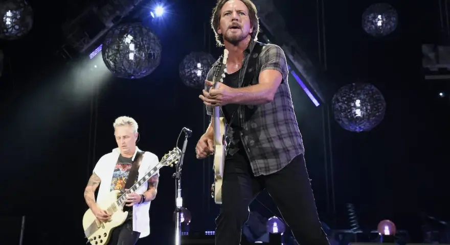 Eddie Vedder et Mike McCready, membres de Pearl Jam, jouent sur scène sous des sphères lumineuses.