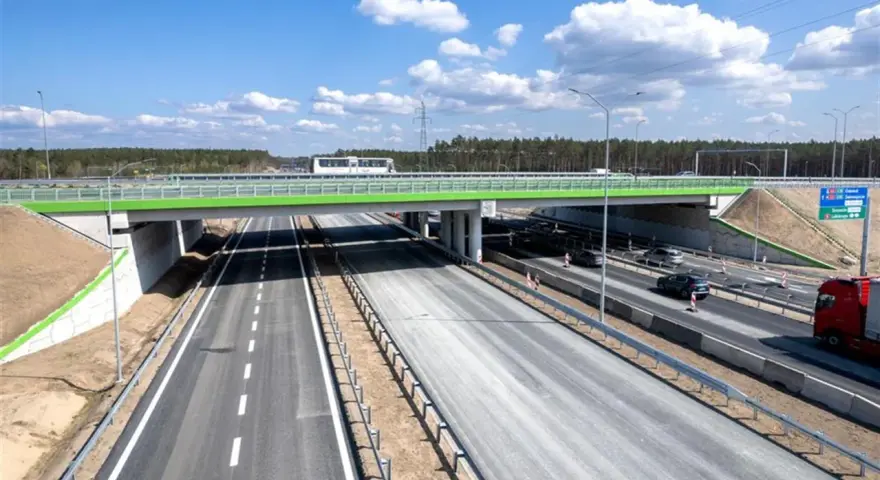 Nowa autostrada A6 z zielonym wiaduktem i ruchem samochodowym.