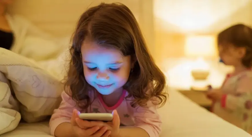 Dziewczynka zafascynowana ekranem telefonu. Jak odzwyczaić dziecko od telefonu? Czas na alternatywy!