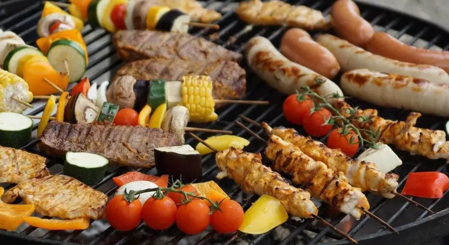 Kolorowe szaszłyki z warzywami i kurczakiem, kiełbaski i mięso na grillu – idealne co na grilla dla dzieci i dorosłych.