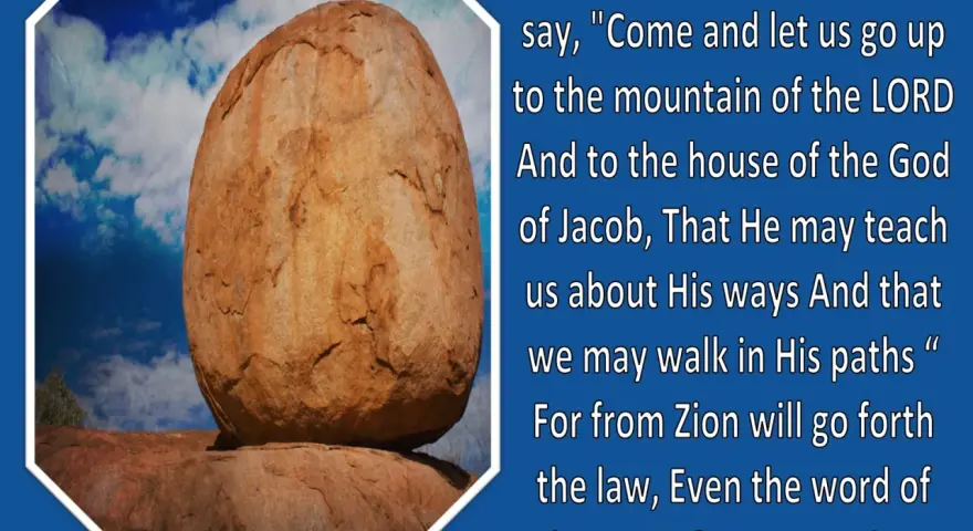 A large, weathered boulder rests precariously on smaller rocks under a blue, cloudy sky, illustrating a verse from Micah in the Bible.
