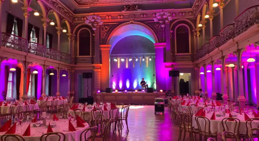 Elegancka sala balowa z oświetleniem tworzącym nastrój. Zastanawiasz się, ile kosztuje wynajęcie profesjonalnego dekoratora światłem na event?