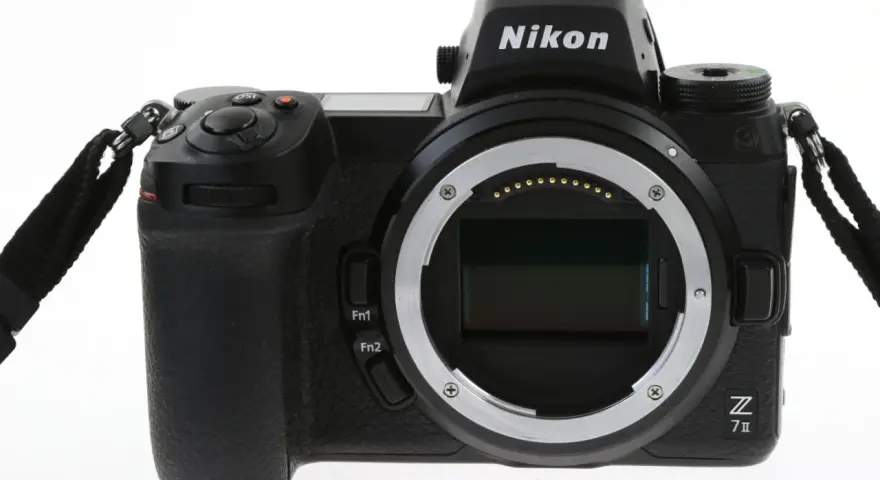 Czarny aparat Nikon Z7 III z obiektywem bez obiektywu, widoczny z przodu, z paskiem na nadgarstek.