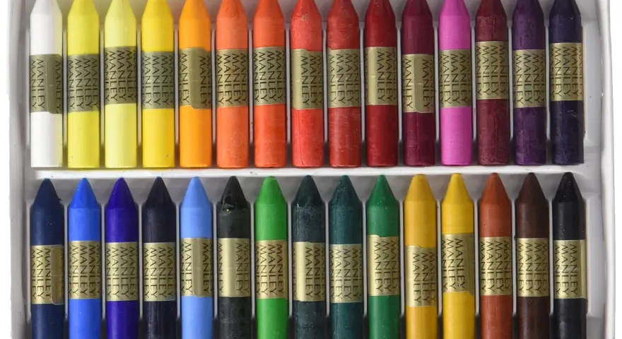 Ceras Manley de colores variados en una caja, dispuestas en dos filas.