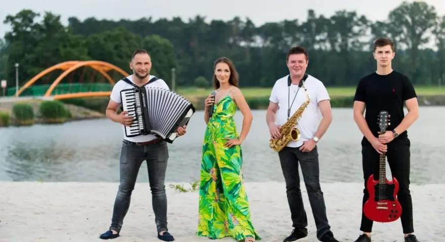 Teraz my - zespół skład: akordeonista, wokalistka, saksofonista i gitarzysta pozują na plaży.