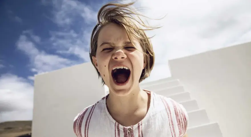 Kind schreit laut, Haare wehen im Wind. Ein Moment, der an einen affektive Dysregulation test erinnert.