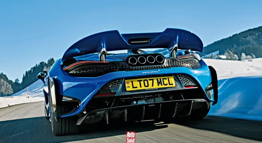 Niebieski McLaren 765LT z czterema końcówkami wydechu pędzi po ośnieżonej drodze w górach.