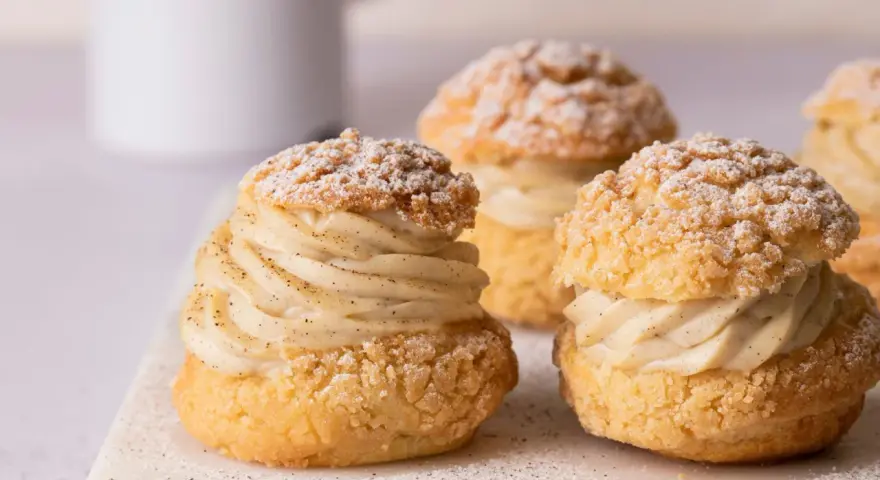 Trois délicieux choux garnis de crème pâtissière à la vanille, saupoudrés de sucre glace. Un vrai plaisir gourmand à base de pâte à choux.