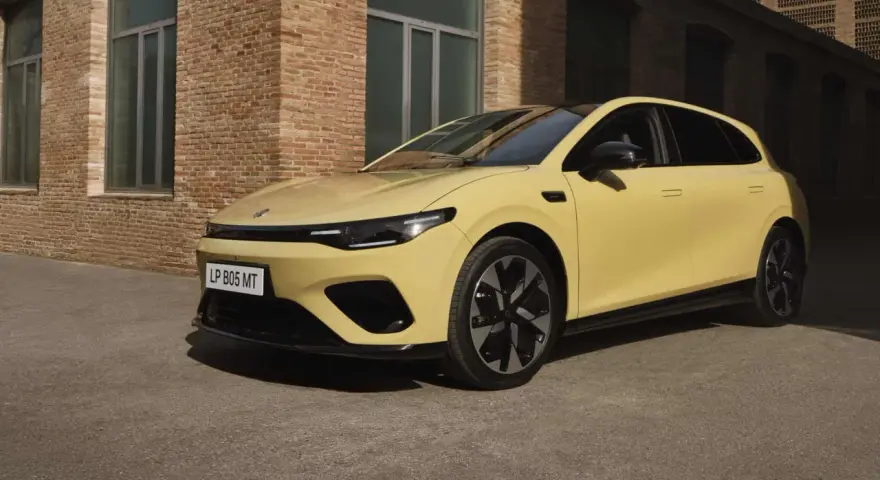 Żółty Leapmotor B05 z czarnym dachem i felgami, zaparkowany przed ceglanym budynkiem.
