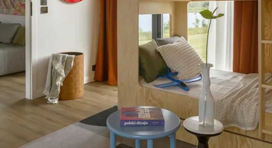 Un lit superposé dortoir maternelle en bois, avec des coussins douillets et un avion bleu pour l'aventure.