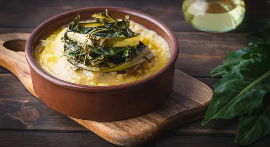 Polenta cremosa con cicoria in padella, un piatto rustico e saporito.