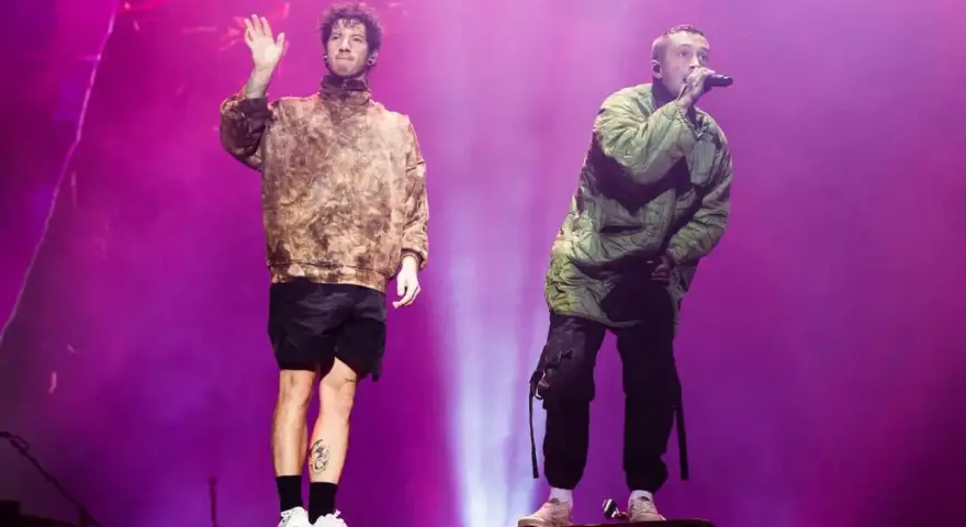 Tyler Joseph i Josh Dun z twenty one pilots na koncercie. Jeden wita publiczność, drugi śpiewa.