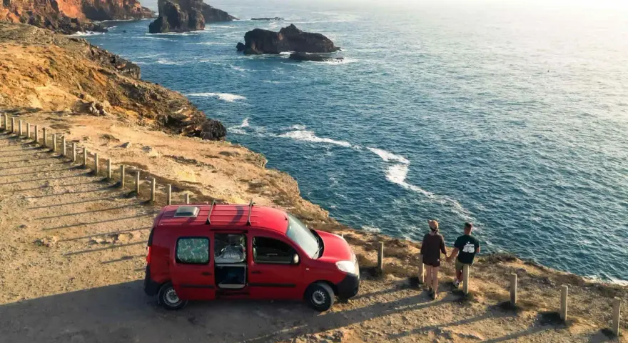 Para z kamperem na klifie w Portugalii, podziwiająca ocean. Niezapomniana podróż kamperem po Portugalii.