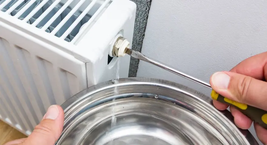 Lufta elementet för att få bort luft. Vatten rinner ner i en skål när en skruvmejsel används för att öppna ventilen.