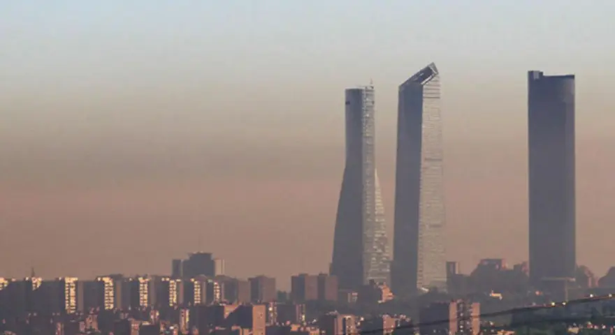 Edificios altos se alzan en una bruma densa, sugiriendo una ciudad mas contaminada del mundo.