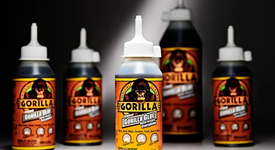 Several bottles of Gorilla Glue are displayed. The front bottle shows "how much weight can Gorilla Glue hold" is a question answered by its "Incredibly Strong" bond.