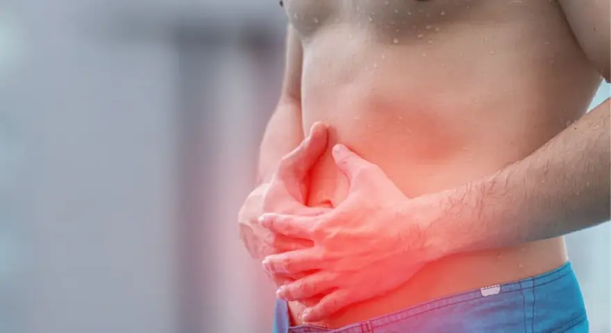 Homme tenant son ventre, zone rouge indiquant une douleur, possible déchireure abdominaux.
