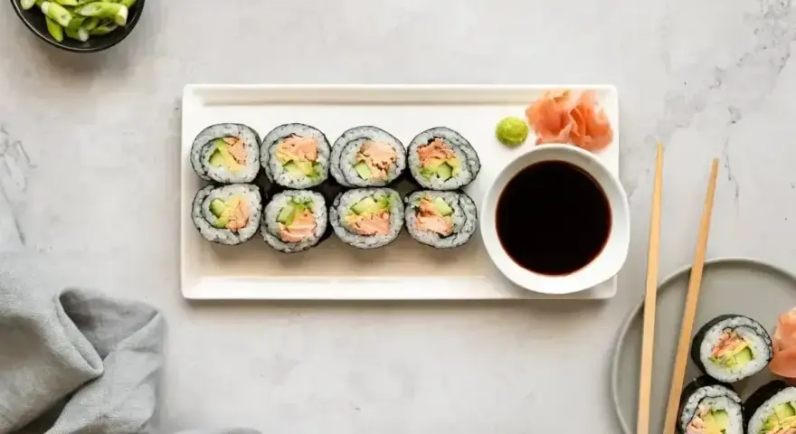Smaczne hosomaki z łososiem i awokado, podane z sosem sojowym i wasabi.