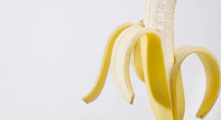Połówka obranego banana, idealna przekąska przed czy po treningu, dostarcza energii.