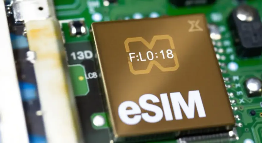Närbild på ett gyllene chip med texten "eSIM" och en stiliserad symbol. Detta digitala simkort är en del av ett kretskort.