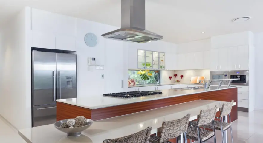 Cocina moderna con isla, electrodomésticos de acero inoxidable y encimera de cuarzo. Ideal para calcular el reforma cocina precio aproximado.