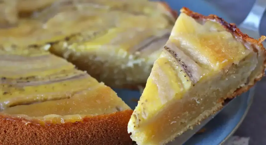Un delicioso bizcocho de plátano, con trozos de fruta dorados y una base esponjosa, listo para ser disfrutado.