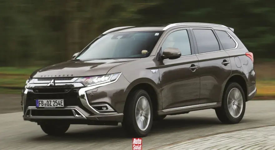 Brązowy Mitsubishi Outlander PHEV jedzie po drodze.