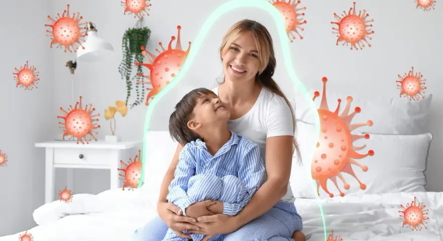Mama tuli dziecko, które miało kaszel w nocy. Wokół nich wirusy, ale chroni je zielona bariera.