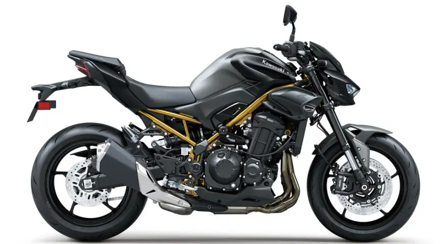 Stylowy, czarny Kawasaki Z900 z widoczną złotą ramą, gotowy na podbój dróg.