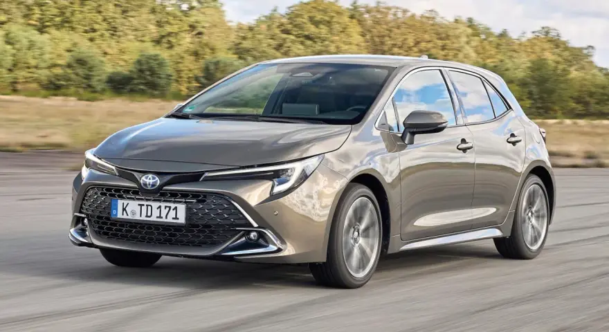 Grauer Toyota Corolla 2.0 Hybrid fährt auf Straße. Mögliche Probleme mit dem Hybridantrieb sind hier kein Thema.