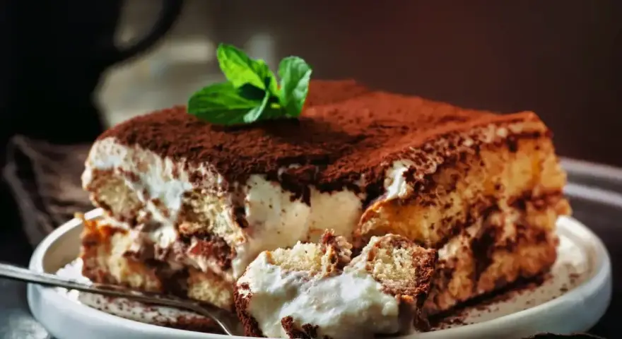 Puszyste, kremowe tiramisu, posypane kakao i udekorowane miętą. Wygląda jak najlepsze tiramisu na świecie!