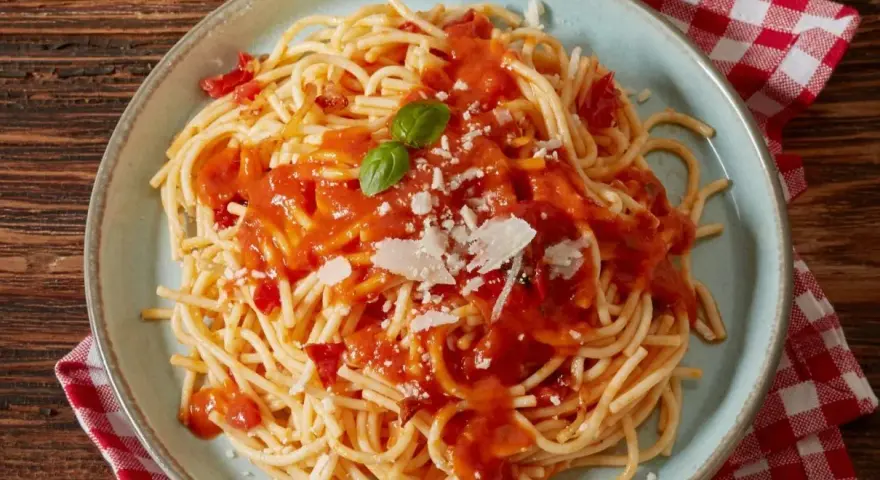 Pyszne spaghetti z sosem pomidorowym, parmezanem i bazylią. Czy to Makaron Barilla czy De Cecco? Trudno odróżnić!