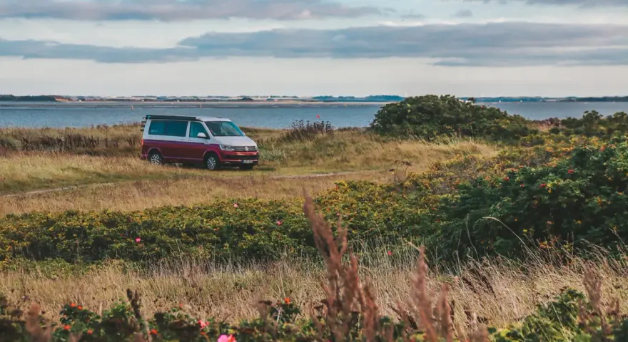 Husbil parkerad vid en kustväg i Danmark, redo för ett äventyr. En perfekt roadtrip danmark-upplevelse.