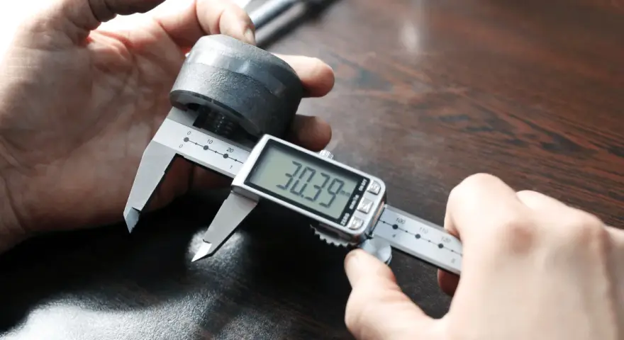 Precyzyjne pomiary: jak mierzyć suwmiarką cyfrową element metalowy, odczyt 30.39 mm.