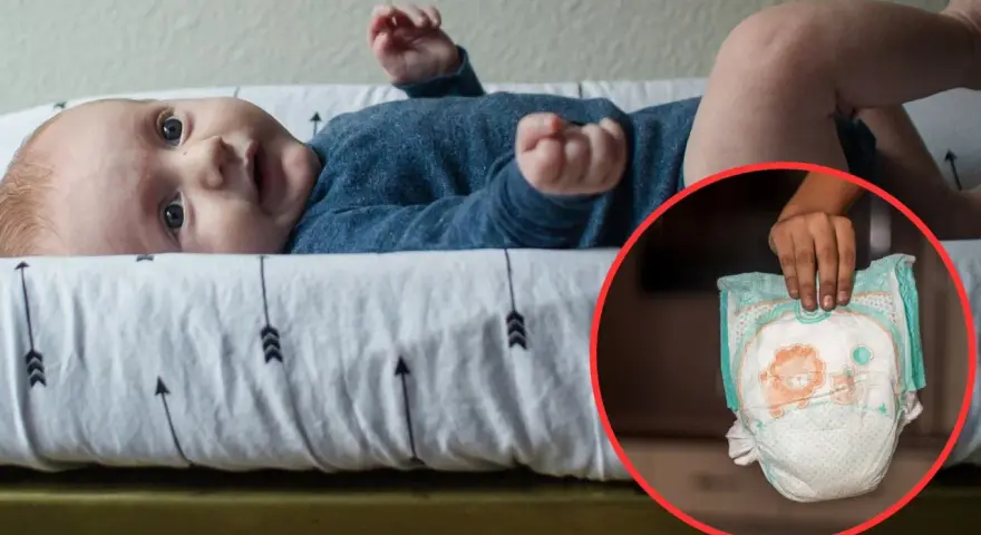 Niemowlę na przewijaku, obok pieluszka. Czas na zmianę pieluszki na większą?