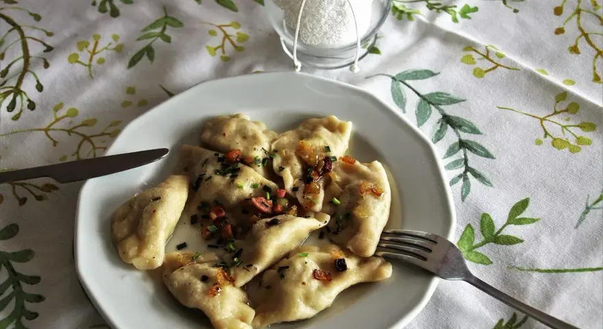 Pyszne pierogi z boczkiem i cebulką, gotowe do jedzenia. Idealny przepis na obiad.