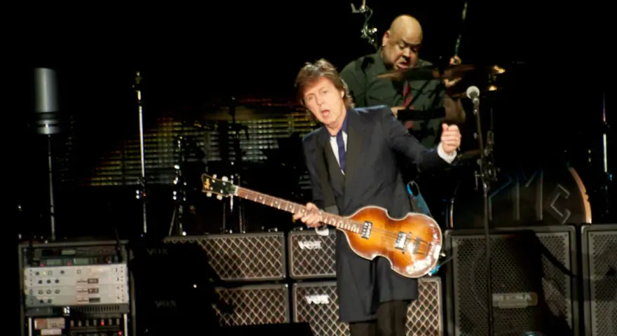 Paul McCartney na jednym ze swoich koncertów, grając na gitarze basowej. W tle perkusista.
