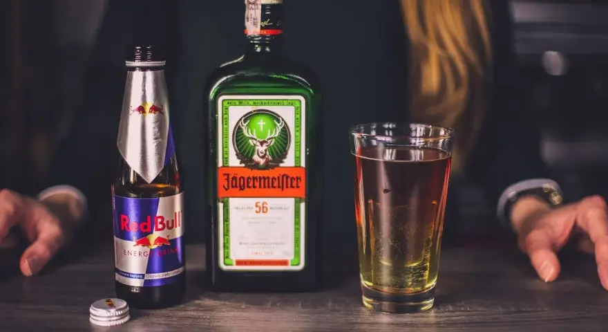 Butelka Jägermeistera, Red Bulla i szklanka z drinkiem. Czy jagermeister to whisky? Nie, to ziołowy likier.