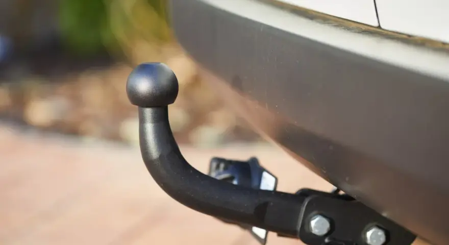 Gancio traino nero montato sul paraurti di un'auto, pronto per il traino secondo il codice della strada.