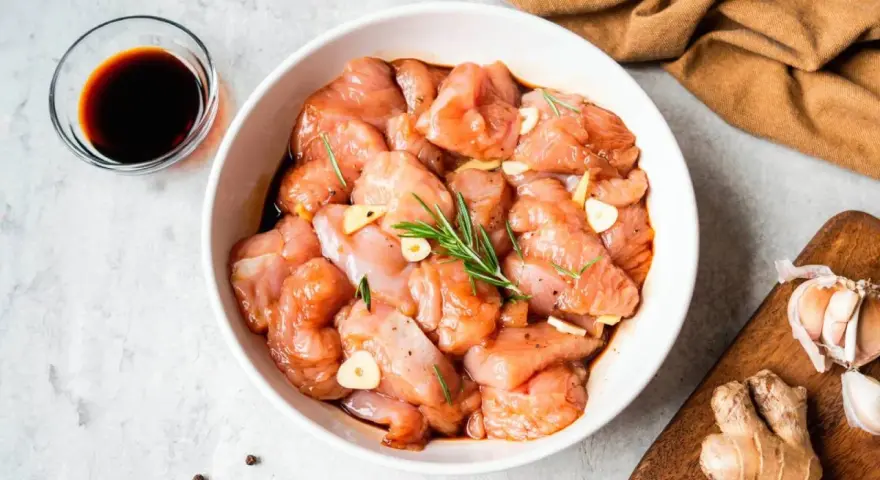 Troceado de pollo marinado con ajo y romero, listo para deliciosas recetas.
