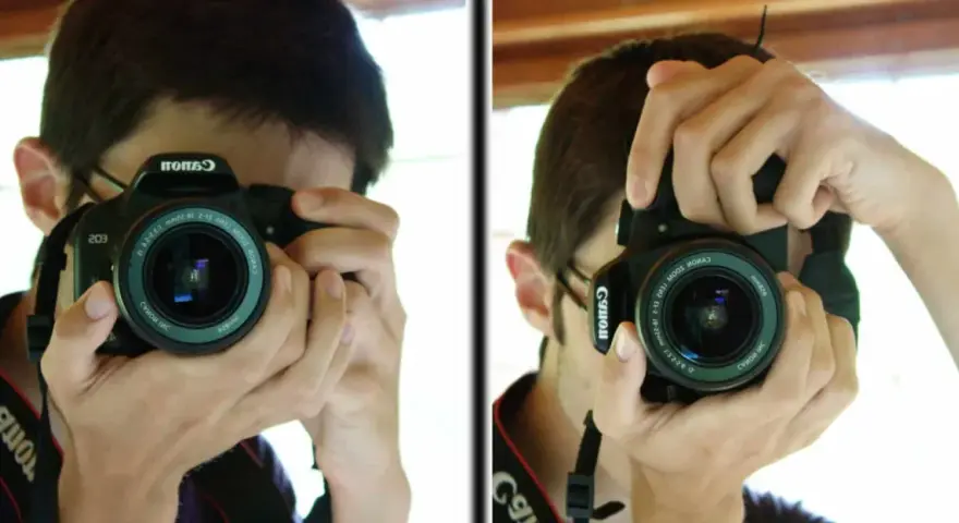 Un jeune homme apprend à photographier, tenant un appareil Canon pour capturer son reflet.