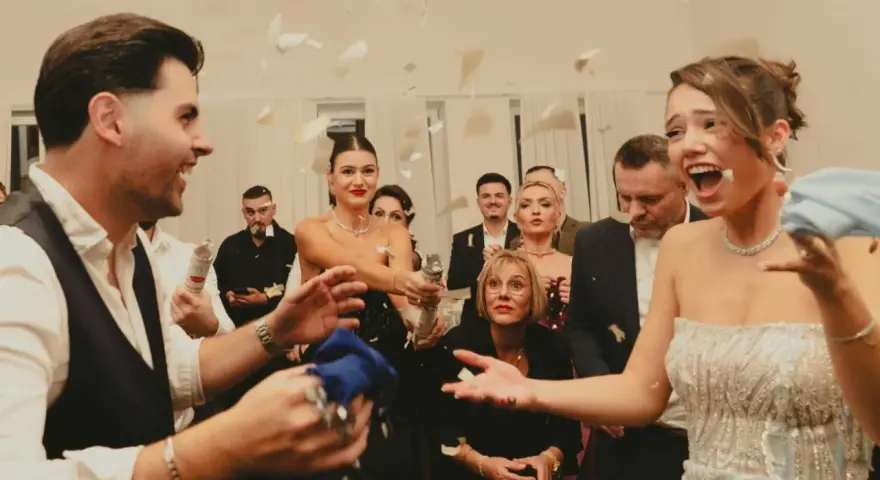 Wesele w pełni! Goście sypią konfetti, a młoda para cieszy się chwilą. Czy osoba towarzysząca daje prezent na wesele?