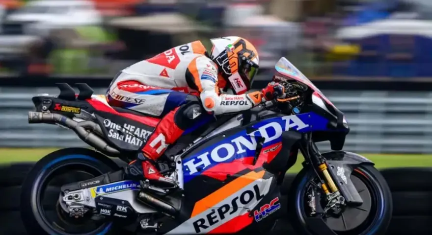 Piloto del Repsol Honda Team en plena carrera, con su moto de competición luciendo los colores icónicos.
