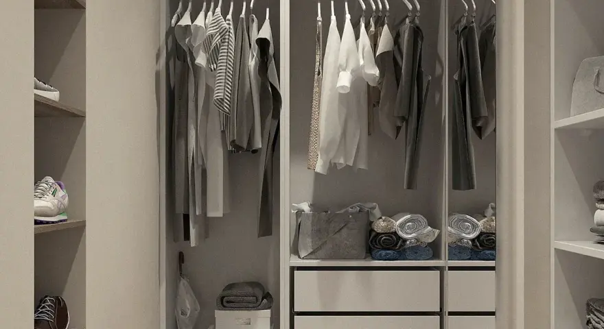 Un impecable fondo de armario mujer con ropa colgada y doblada, zapatos en estantes y accesorios organizados.