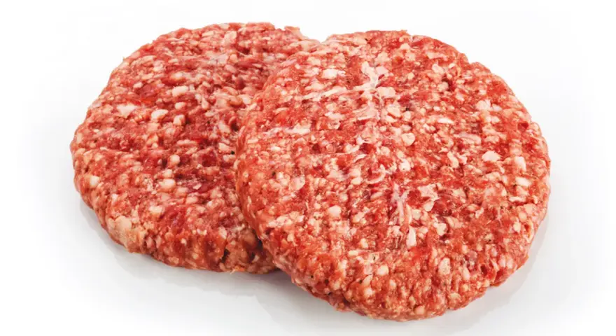 Dwa surowe kotlety mielone na burgery na białym tle.