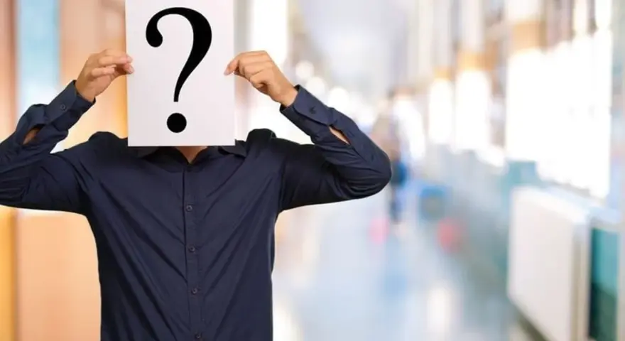 Un homme en chemise bleue cache son visage derrière un point d'interrogation. Une métaphore visuelle pour la quête : comment retrouver une personne sans son nom et prénom ?