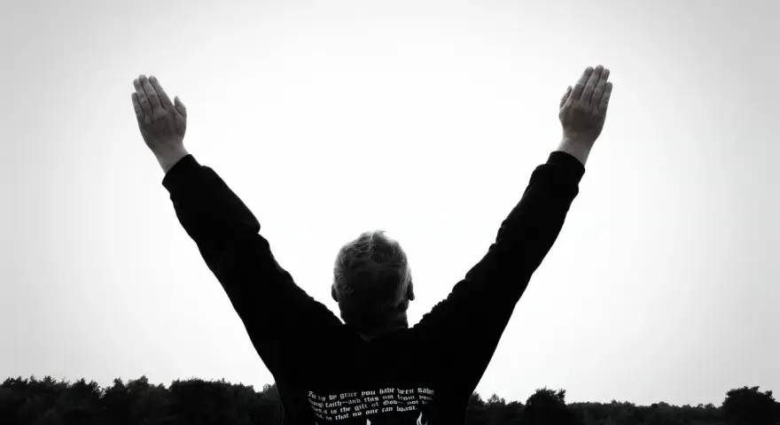 Mann mit erhobenen Armen im Freien, inspiriert von Psalm 92.