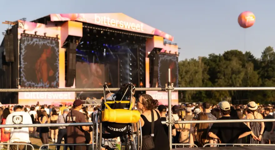 Dwie osoby, jedna na wózku, dzielą intymną chwilę na festiwalu bittersweet.